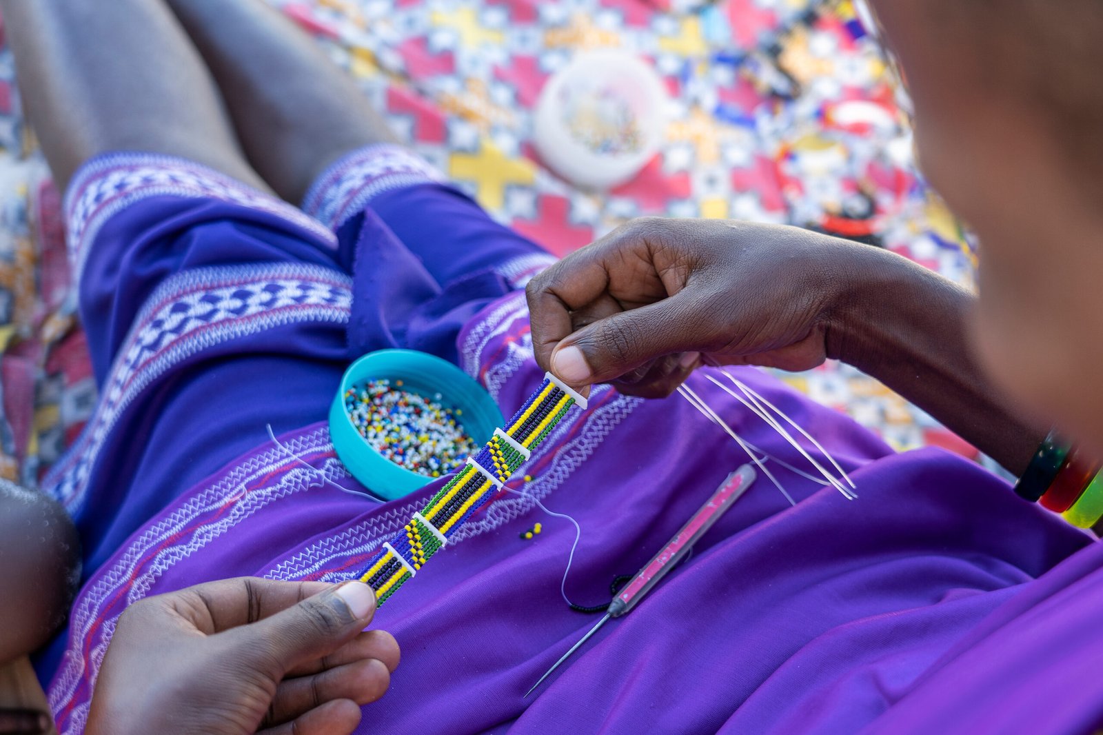 making of handmade jewellery. masai african women hands, top view, close up. island of zanzibar, tanzania, africa